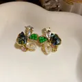 Detailed macro view of elegant floral stud earrings with colorful crystals and pearls - Blue Green