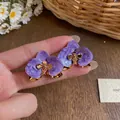 Nahaufnahme violetter Orchideen-Ohrstecker mit Gold-Finish und Emaille-Detail - Lila