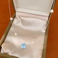 Detailed view of a light blue zircon flower necklace with elegant pearls in a gift box - Necklace Only (HN12529) / Silver-Blue