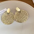 Detail von goldfarbenen runden hohlen Tropfenohrringen mit strukturiertem Muster. - Runder Hohler Stil (Gold) / Gold