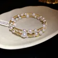 Detail view of an elegant gold triple-layered wrap bracelet with pearls and stones - Double Layer Style / Gold