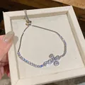 Detailansicht eines silbernen Kreuzarmbands mit Zirkonia-Steinen und verstellbarer Kette - Kreuzarmband (HB5450) / Verstellbar / Weiß