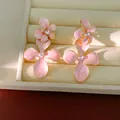 Detailed view of pink enamel flower stud earrings featuring a sparkling central rhinestone - Pink