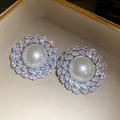 Detailed close-up of vintage style stud earrings with large central pearl and zircon halo - Silver (Silver Pin)