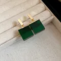 Macro view of elegant retro green resin square pendant earrings in a jewelry box - Earrings / Gold-Green
