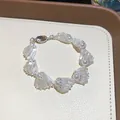 Elegant white shell and pearl beaded bracelet detailed view on beige display tray - Bracelet / White