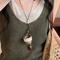 Detail view of handmade woven basket and acorn pendant necklace in forest style on model - Coffee & White - Acorn Style