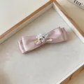 Detail der rosa Stoffschleife-Haarklammer mit Perlenblume und Strasssteinen - Zirkonia-Stil / Einzelstück / Rosa
