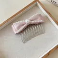 Detailaufnahme eines Haarkamms mit rosa Satinschleife und eleganten weißen Perlenverzierungen - Perlenstil / Rosa