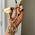 Detailed close-up view of a bohemian silk scarf necklace featuring a large golden resin pendant - Gold-Yellow