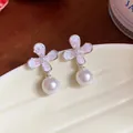 Primo piano di eleganti orecchini con fiori rosa e perle su un piatto di ceramica - Rosa (HE31998) / Argento