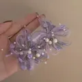Dettaglio orecchini a fiore in raffia viola fatti a mano con perle e ago d'argento - Stile Nappa Intrecciata in Rafia / Viola