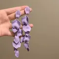 Vista dettagliata di eleganti orecchini a nappa con petali viola con texture opaca raffinata - Stile Smerigliato a Nappa Lunga / Viola