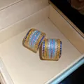 Macro view of vintage-style square stud earrings with colorful pavé cubic zirconia - Gold-Multicolor