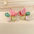Close-up of floral jewelry charms with pink enamel petals and multi-color teardrop crystals - Silver Needle / Pink-Green