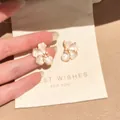 Close-up detail of elegant shimmering flower-shaped earrings displayed on a gift card pouch. - Pearly Floral Stud Earrings (6#) / Gold-Pink