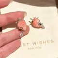 Close-up of cute strawberry enamel earrings with silver needle and teardrop crystal charm. - Strawberry Drip Oil Earrings (4#) / Pink-Red