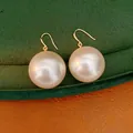 Detail view of 18k gold plated large pearl drop earrings on velvet background - Hook Style / Silver Earring Post-White