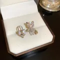 Close-up view of asymmetric heart lock and crystal teddy bear stud earrings in a box - Heart Padlock Bear Stud Earrings (17#) / Silver