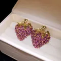 Gros plan de boucles d'oreilles fraises plaquées or avec des strass violets fins - Tige en Argent (HE34305) / Violet