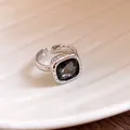 Macro view of a silver open ring featuring a faceted dark stone and ribbed texture detail. - Square Style / Gray