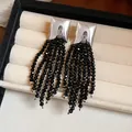 Gros plan de boucles d'oreilles carrées en argent avec de longs pompons en perles noires - Plaqué Argent Noir