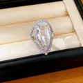 Close-up detail of a pear-cut zircon ring with an elegant halo setting in a box - Water Drop Open Ring (HR3567) / Silver-White