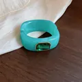 Detailopname van turquoise acryl armband met groen kristal op een houten achtergrond - Vierkante Strass Armring / Groen