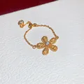 Primo piano di un anello a catena fiore d'oro con zirconi bianchi su base in pelle - Forma di Fiore (Regolabile) / Zirconia Gialla (HR3513)
