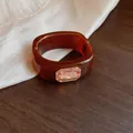 Detail van een amberkleurige vierkante harsarmband met een luxe rechthoekig kristal - Vierkante Strass Armring / Bruin