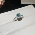 Detailed view of an elegant ring featuring a teal gemstone and sparkling zircon halo - Open Adjustable Ring / Silver Band-Cyan Zirconia