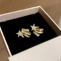 Detailed view of gold shooting star ear clips set with sparkling zircon stones - One Pair / Gold