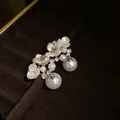 Detailed view of elegant French vintage floral pearl earrings in a luxury jewelry box - Pearl Flower Dangle Style