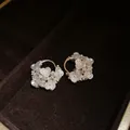 Close-up macro detail of French vintage silver needle earrings with white pearls and flowers - Stereo Flower Style
