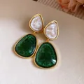 Macro view of vintage green and cream resin triangle drop earrings with elegant gold trim - Green
