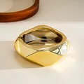 Close-up of a stylish chunky geometric gold bangle with a polished multi-faceted design - Gold