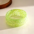 Close-up of a neon green resin geometric bangle with iridescent triangle patterns. - Green Holographic