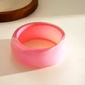 Macro view of a thick pink resin bangle bracelet featuring a subtle glitter shimmer finish - Pink Iridescent