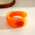 Macro view of orange resin geometric bangle with red wax seal pattern detail - Orange