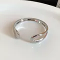 Detailed macro view of irregular polished silver open metal bangle with minimalist design - Irregular Water Drop Style / Silver