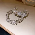Detailed view of sparkling cubic zirconia flower patterns on C-shaped silver earrings. - C-Shaped Flower (Silver Post) / Clear