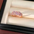 Close-up of an elegant rose gold ring featuring purple and white cubic zirconia stones - Purple