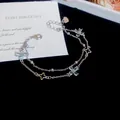 Close-up of double-layer silver bracelet with clear flower-shaped zircon charms - Double Layer Four-Leaf Flower Style / Silver Tone - Blue Zirconia