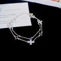Detailed view of a silver double-layer bracelet with sparkling zircon clover charms - Double Layer Four-Leaf Flower Style / Silver Tone - White Zirconia