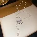 Elegant detailed shot of a retro bow pendant necklace featuring pearls and sparkling zircons - Silver Pink