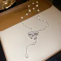 Detailed view of zircon-encrusted bow pendant and elegant pearl beaded necklace chain - Silver