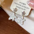 Detailed view of S925 silver star earrings featuring mother of pearl and shiny crystals - Silver