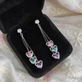 Detailed macro shot of long tassel earrings featuring pink, blue, and purple heart-shaped stones - Heart Style (HE32882) / Silver