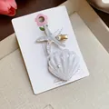 Close-up of sparkly resin starfish and seashell hair clips with elegant faux pearls - 海星和贝壳套装 / Two-Piece Set / White