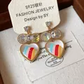 Gros plan de boucles d'oreilles en verre en forme de cœur avec rayures colorées et cristaux - Or (Tige en Argent/Multicolore)